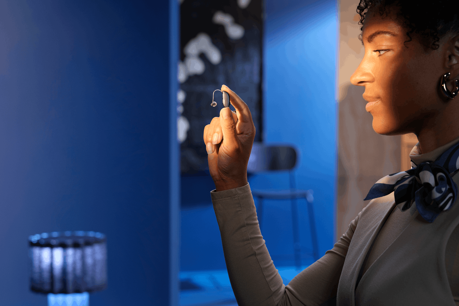 Beltone hearing aid held in hand by woman