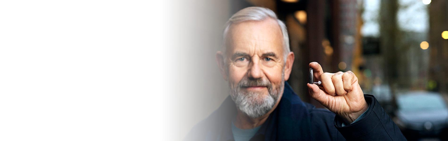 Man holding a Beltone Imagine BTE hearing aid between his fingers