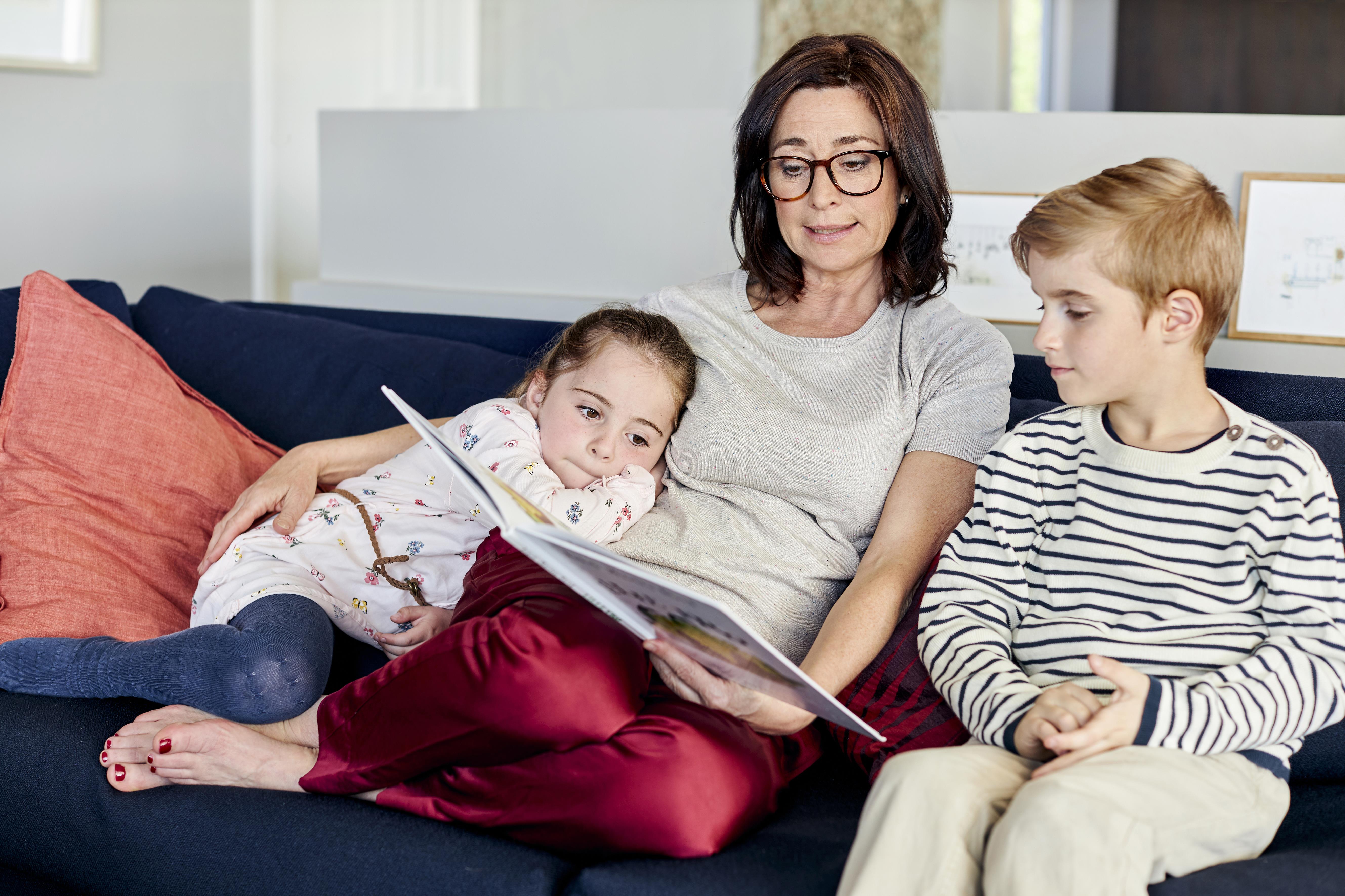 Mulher que usa aparelhos auditivos ReSound LiNX² em um restaurante com sua família.