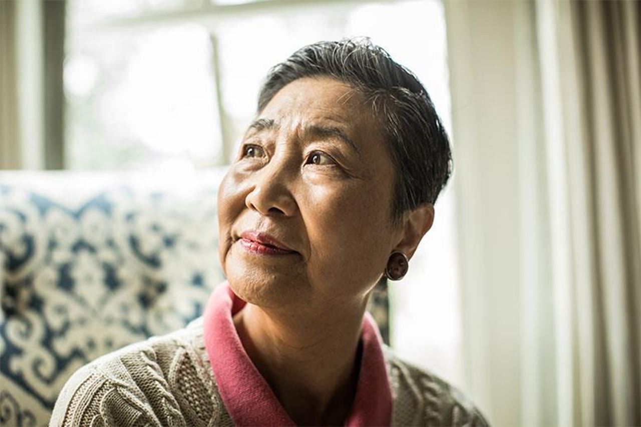 A senior lady sitting by a window