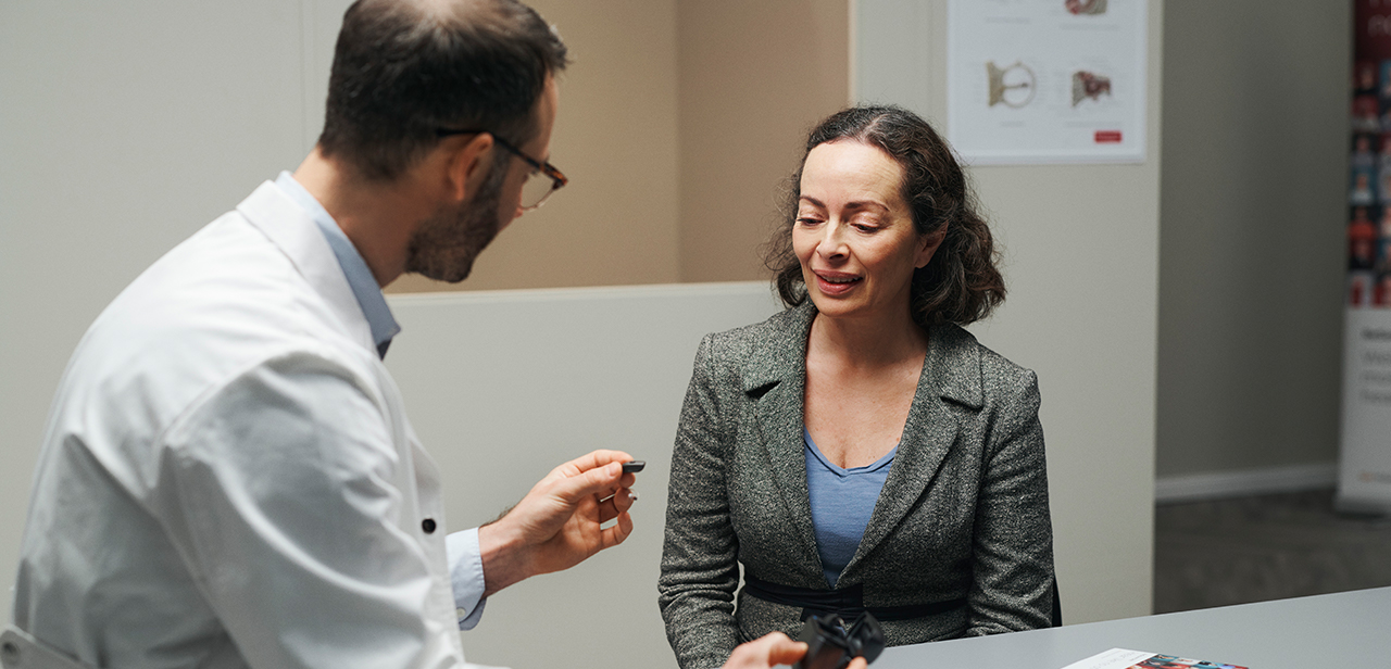 ReSound-Hörgeräteakustiker im Gespräch mit einem Patienten.