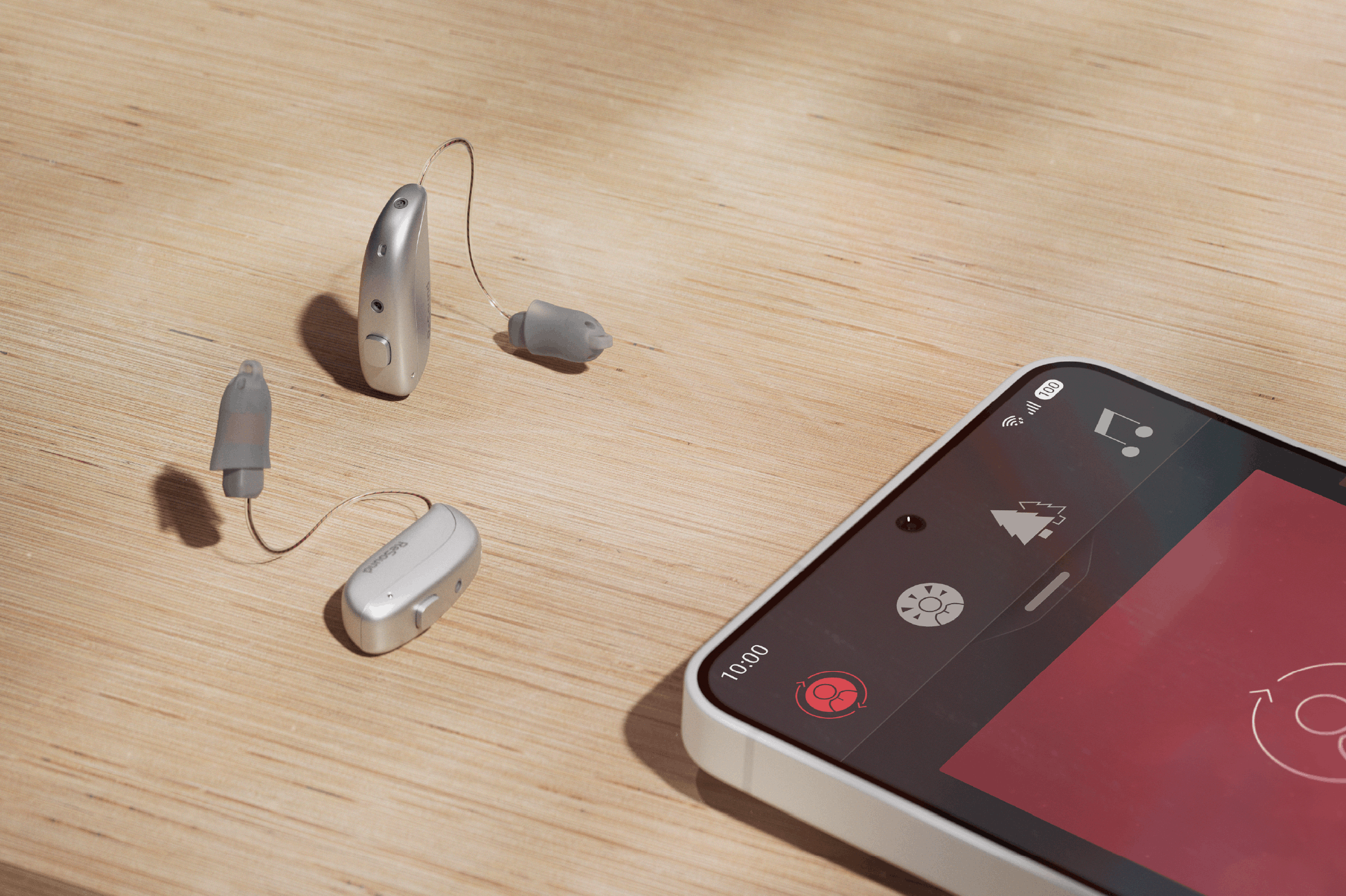 ReSound Sensia microRIE and mobile device displayed on wooden table